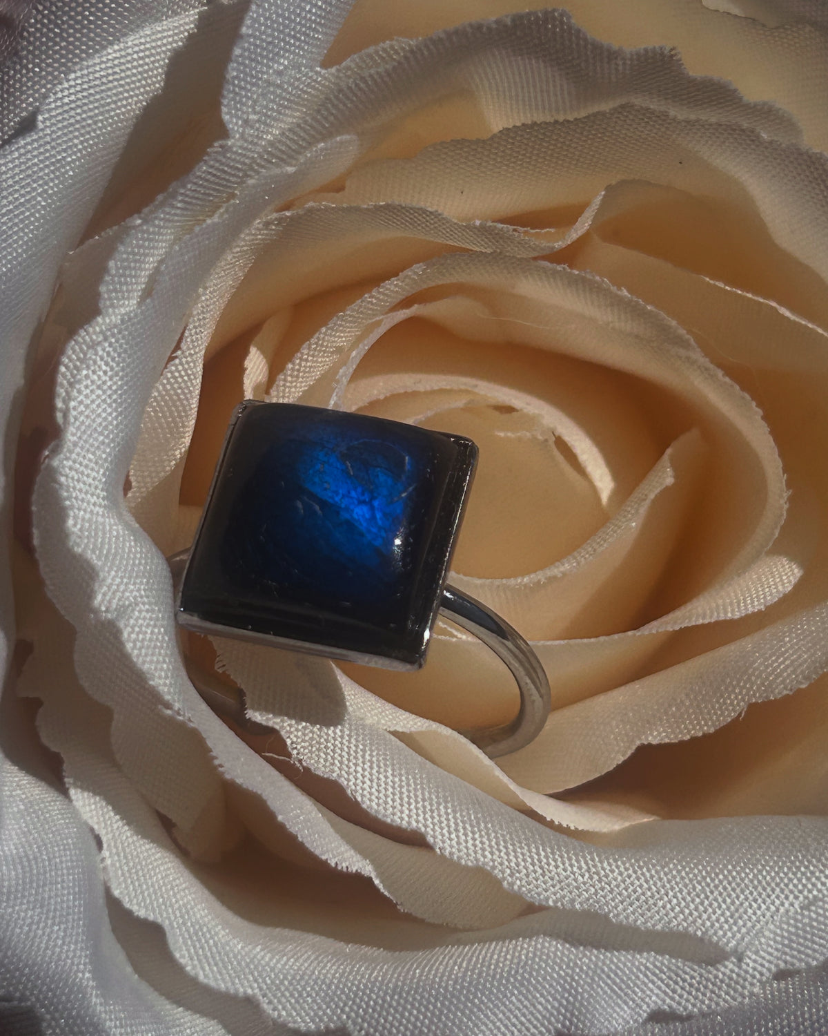 Bague Kaora réglable en acier inoxydable argenté, ornée d’un cabochon carré de 10 × 10 mm en labradorite aux reflets bleus.