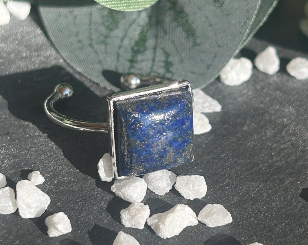 Bague Kaora réglable en acier inoxydable argenté, ornée d’un cabochon carré de 10 × 10 mm en lapis-lazuli bleu profond.