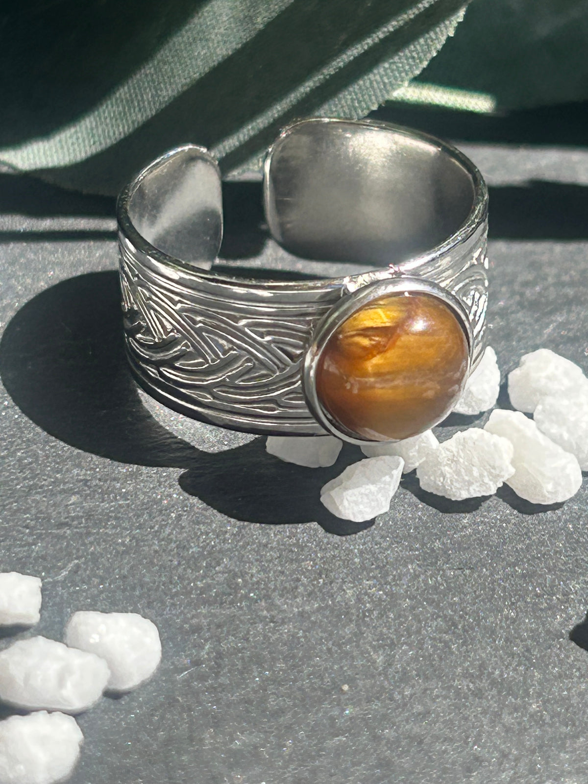 Bague Sylmor réglable à monture large texturée en acier inoxydable argenté, ornée d’un cabochon rond en œil de tigre brun doré.