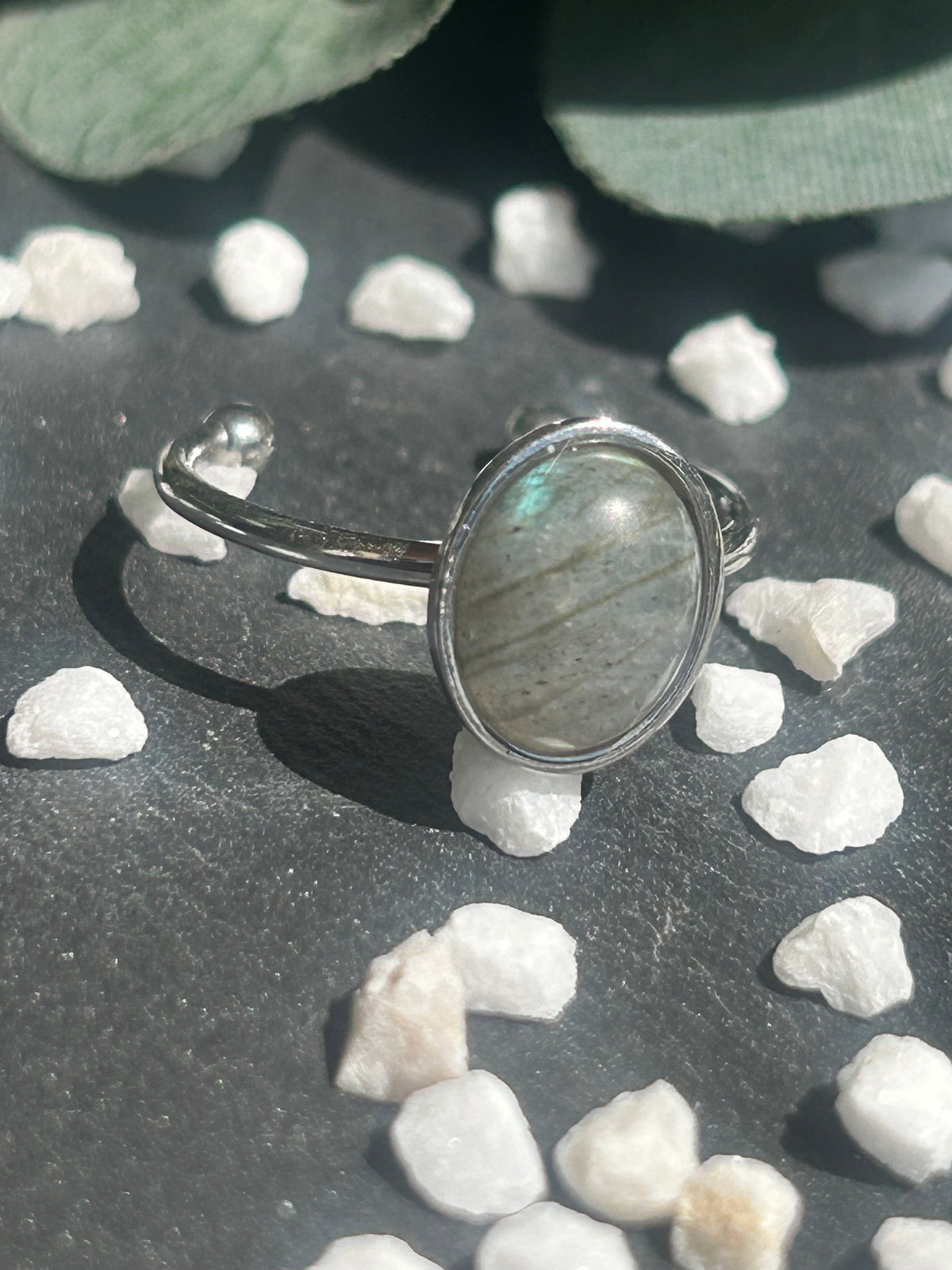 Bague Thémis réglable en acier inoxydable argenté, ornée d’un cabochon ovale en labradorite aux nuances grises.