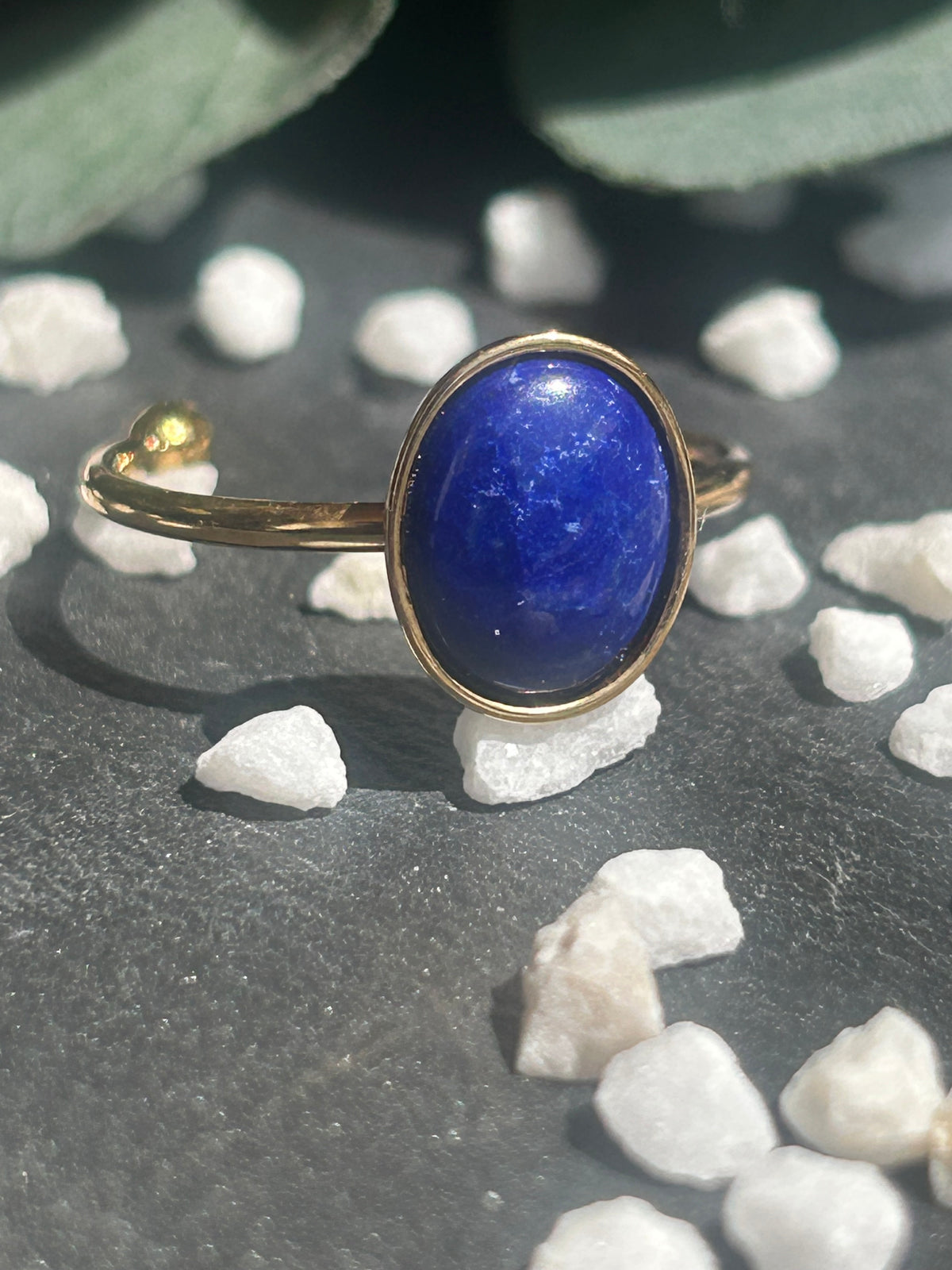 Bague Thémis réglable en acier inoxydable doré, ornée d’un cabochon ovale en lapis-lazuli bleu profond.