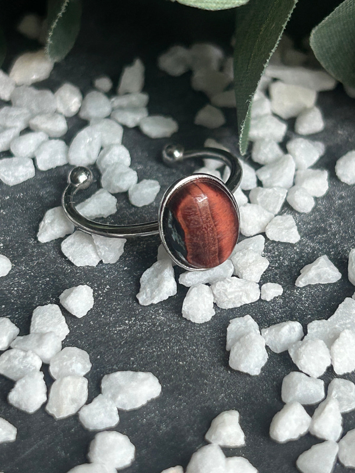 Bague Thémis réglable en acier inoxydable argenté, ornée d’un cabochon ovale en œil de taureau aux nuances rouge brun.