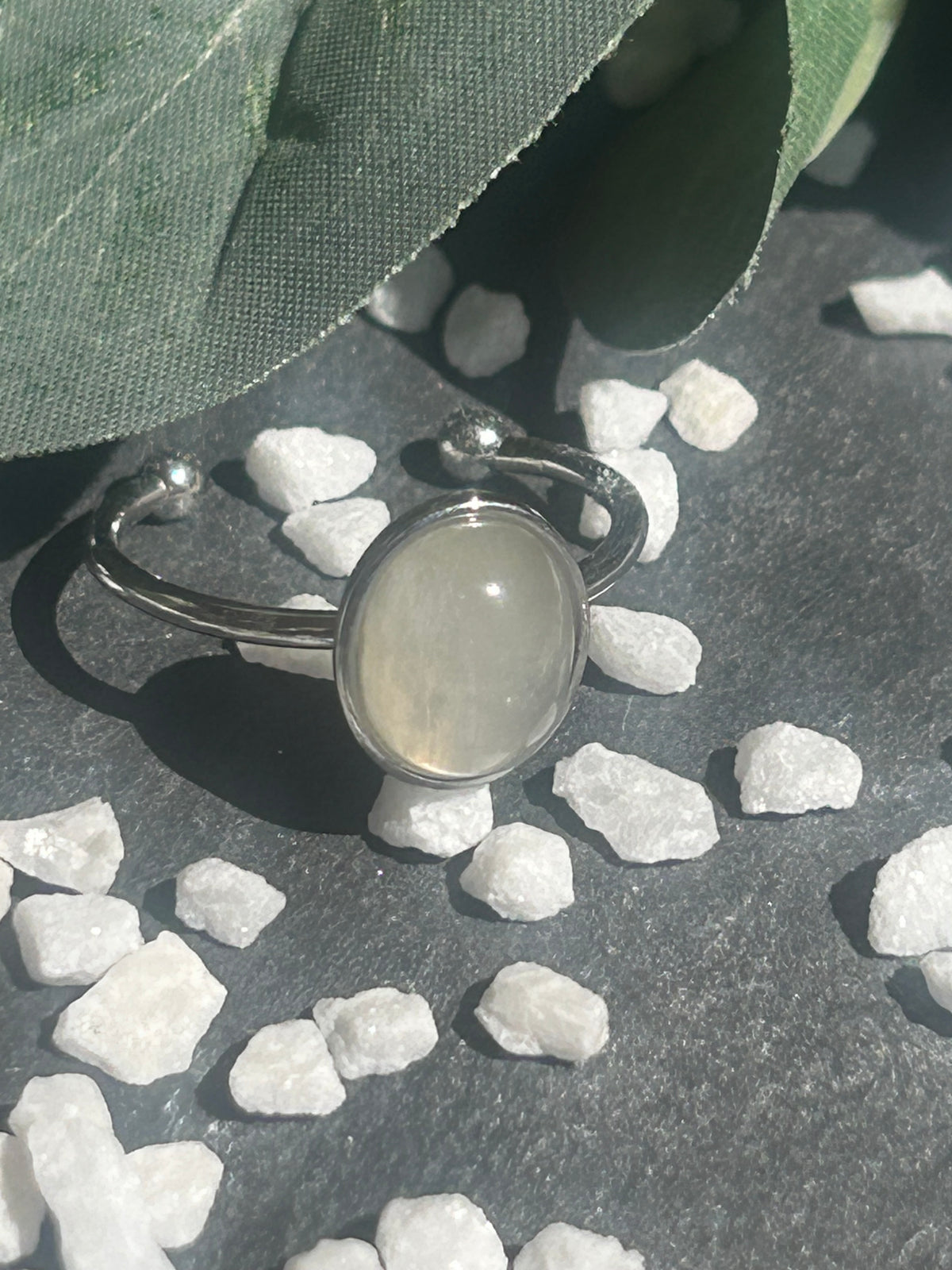 Bague Thémis réglable en acier inoxydable argenté, ornée d’un cabochon ovale en pierre de lune blanche.