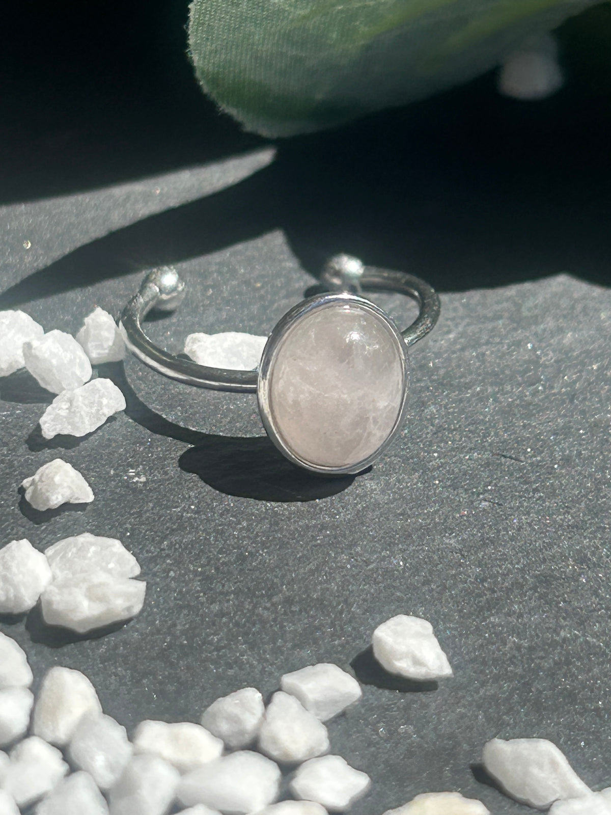 Bague Thémis réglable en acier inoxydable argenté, ornée d’un cabochon ovale en quartz rose pâle.