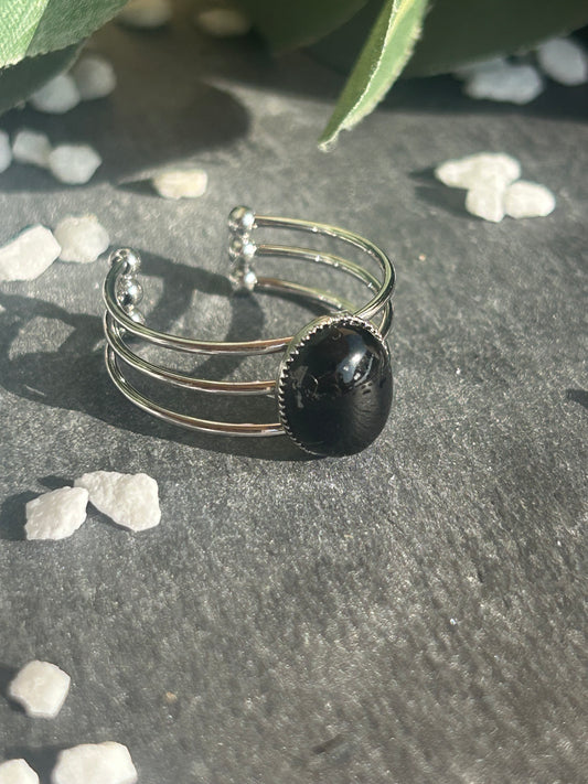 Bague Trinæa réglable à trois anneaux en acier inoxydable argenté, ornée d’une agate noire ovale.