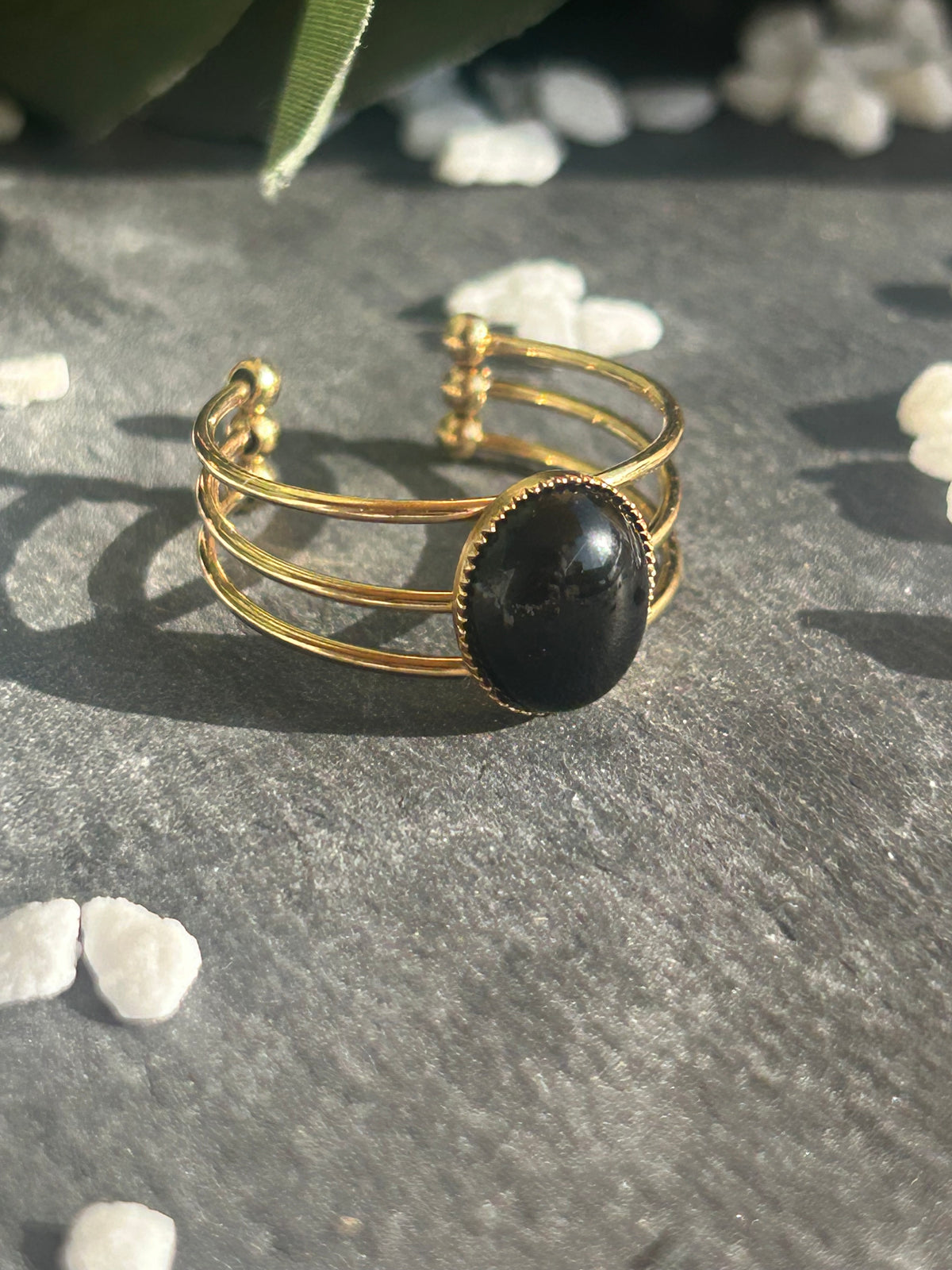 Bague Trinæa réglable à trois anneaux en acier inoxydable doré, ornée d’une agate noire ovale.