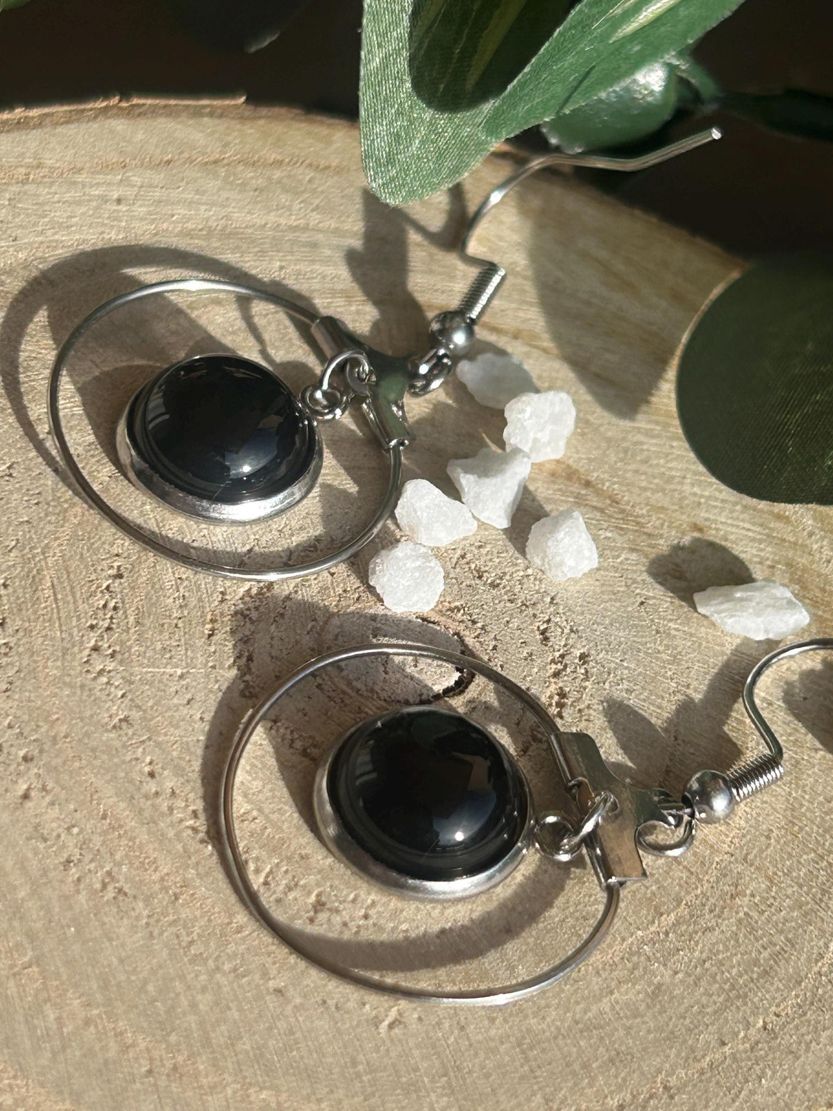 Paire de boucles d’oreilles pendantes Célestia en acier inoxydable argenté, avec des montures circulaires et des cabochons ronds en agate noire.