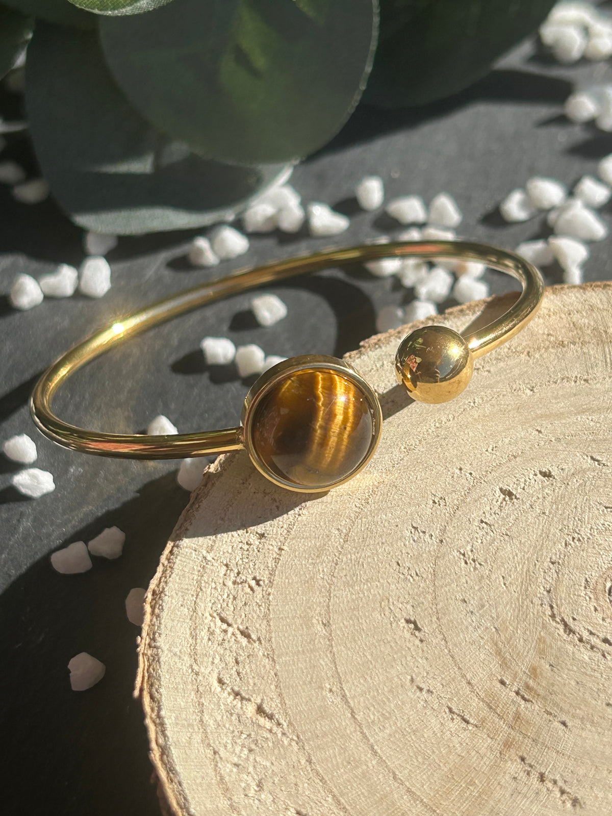 Bracelet jonc Lunae en acier inoxydable doré, orné d’un cabochon rond de 12 mm en œil de tigre brun doré et d’une bille fixe.
