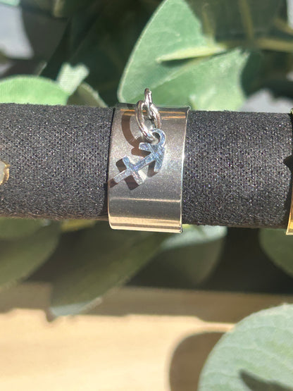 Bague Cassiopée à monture large en acier inoxydable argenté, avec une breloque du signe du Sagittaire suspendue.