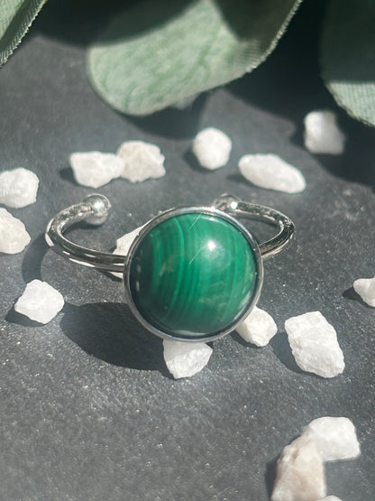 Bague Séléna réglable en acier inoxydable argenté, ornée d’un cabochon rond de 10 mm en malachite verte aux motifs naturels.