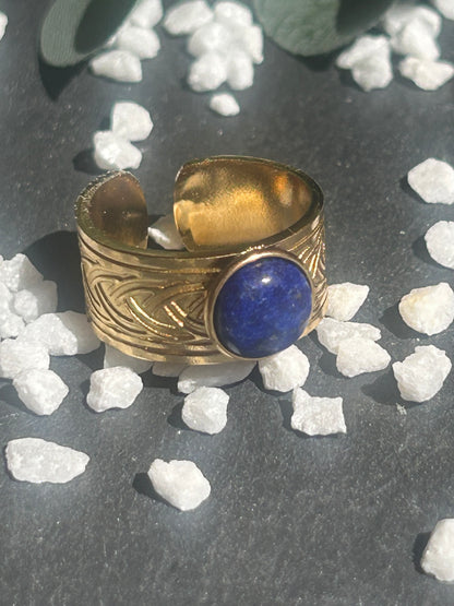 Bague Sylmor réglable à monture large texturée en acier inoxydable doré, ornée d’un cabochon rond en lapis-lazuli bleu.