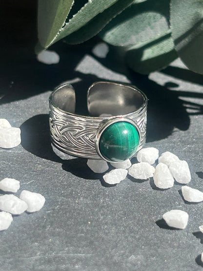 Bague Sylmor réglable à monture large texturée en acier inoxydable argenté, ornée d’un cabochon rond en malachite verte aux motifs naturels.