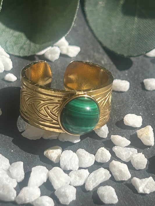 Bague Sylmor réglable à monture large texturée en acier inoxydable doré, ornée d’un cabochon rond en malachite verte aux motifs naturels.