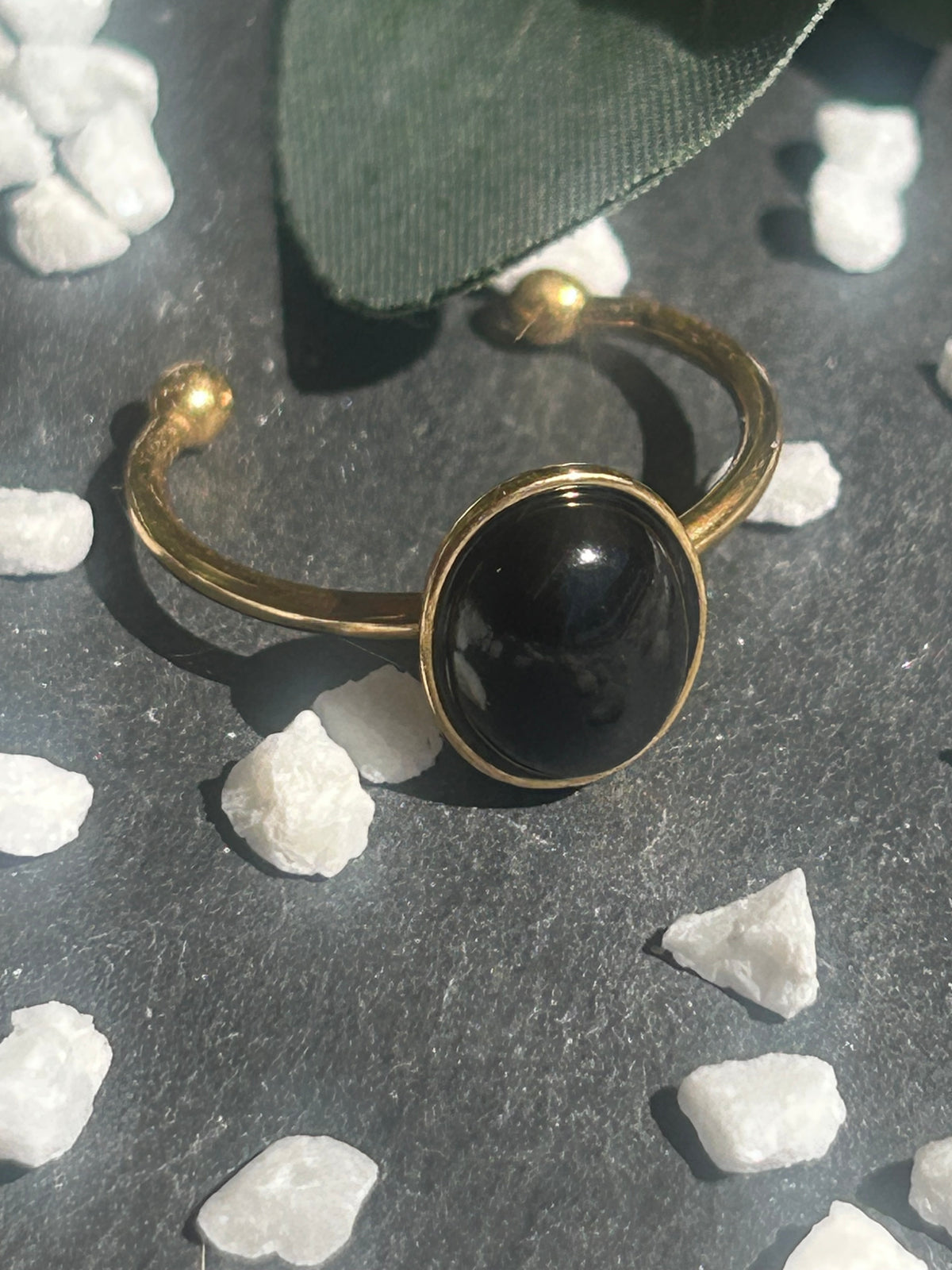 Bague Thémis réglable en acier inoxydable doré, ornée d’un cabochon ovale en agate noire.