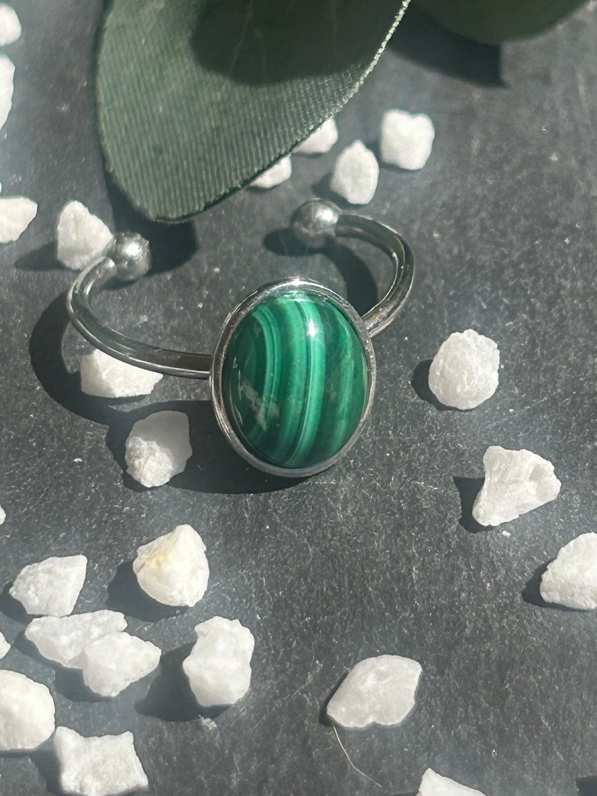 Bague Thémis réglable en acier inoxydable argenté, ornée d’un cabochon ovale en malachite verte aux motifs rubanés.