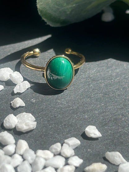 Bague Thémis réglable en acier inoxydable doré, ornée d’un cabochon ovale en malachite verte.
