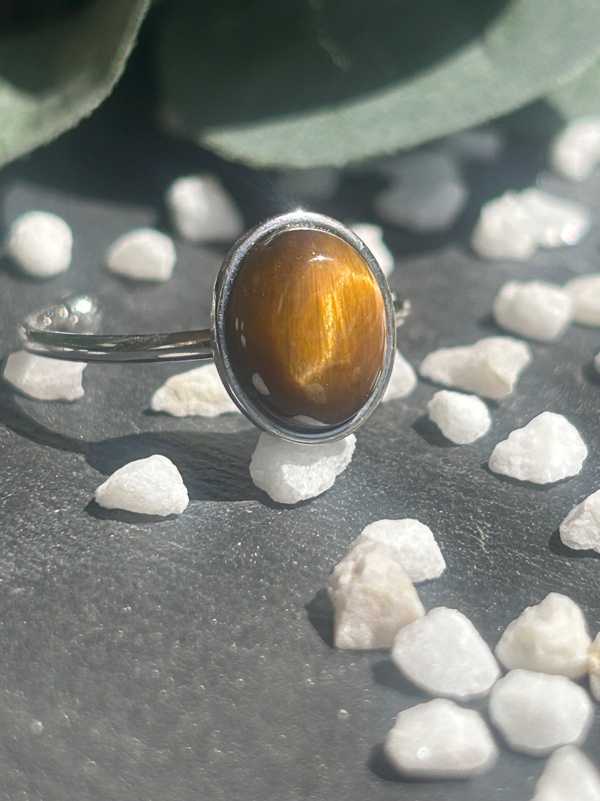 Bague Thémis réglable en acier inoxydable argenté, ornée d’un cabochon ovale en œil de tigre brun doré.