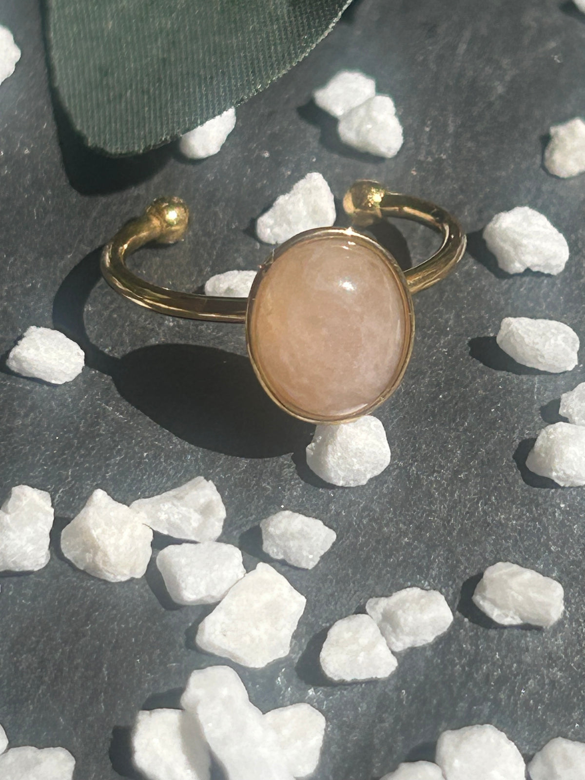 Bague Thémis réglable en acier inoxydable doré, ornée d’un cabochon ovale en quartz rose pâle.