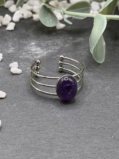 Bague Trinæa réglable à trois anneaux en acier inoxydable argenté, ornée d’une améthyste violette ovale.
