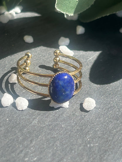 Bague Trinæa réglable à trois anneaux en acier inoxydable doré, ornée d’un lapis-lazuli bleu ovale.