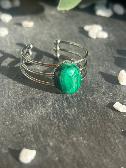 Bague Trinæa réglable à trois anneaux en acier inoxydable argenté, ornée d’une malachite ovale aux motifs verts.