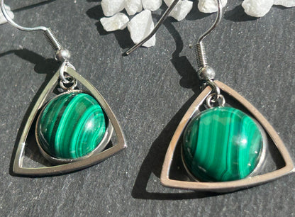 Paire de boucles d’oreilles pendantes Aeltria en acier inoxydable argenté, avec des montures triangulaires et des cabochons ronds en malachite verte aux motifs rubanés.