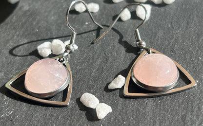 Paire de boucles d’oreilles pendantes Aeltria en acier inoxydable argenté, avec des montures triangulaires et des cabochons ronds en quartz rose pâle.