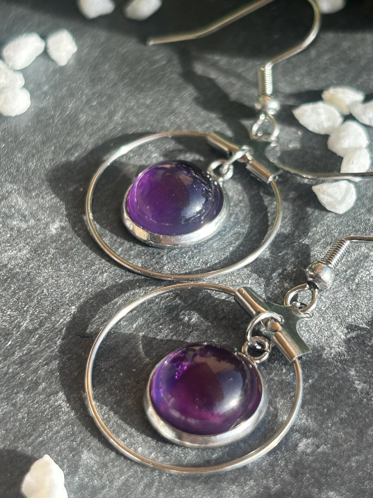 Paire de boucles d’oreilles pendantes Célestia en acier inoxydable argenté, avec des montures circulaires et des cabochons ronds en améthyste violette.