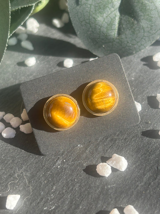 Paire de boucles d’oreilles puces Séléna en acier inoxydable doré, ornées de cabochons ronds de 10 mm en œil de tigre brun doré.