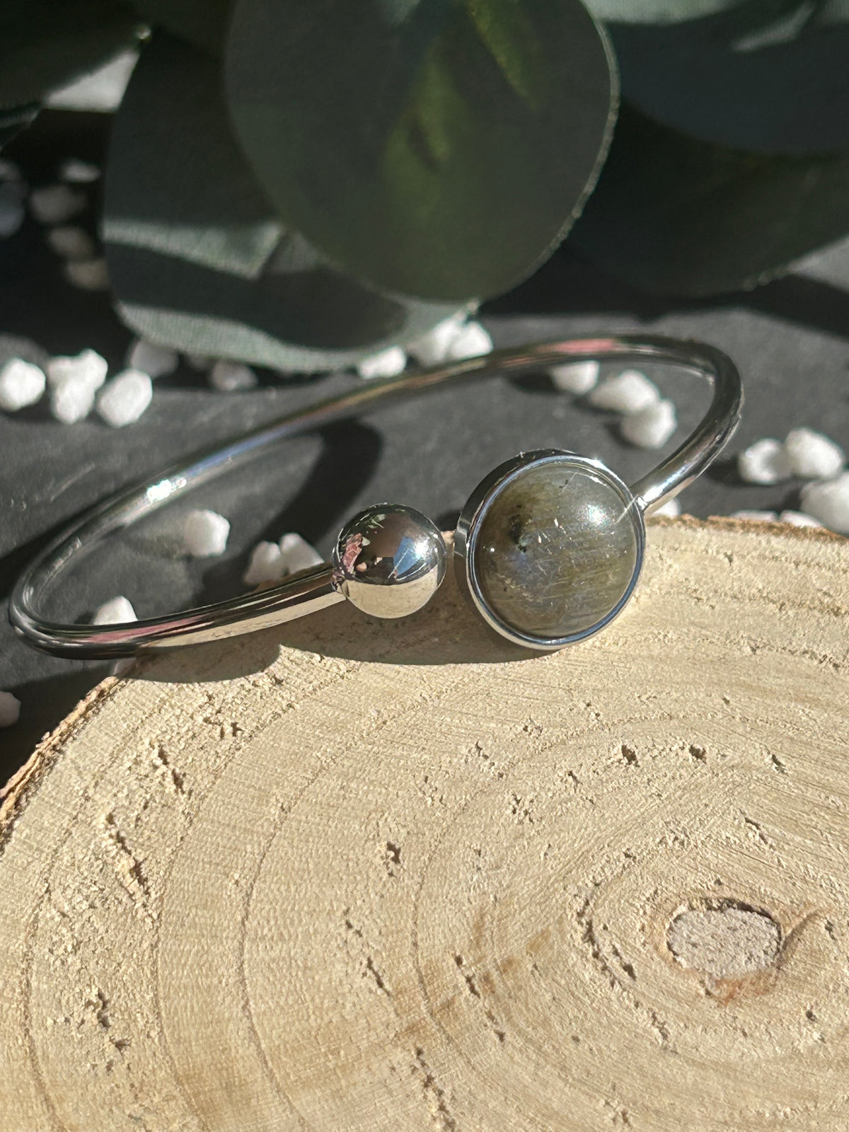 Bracelet jonc Lunae en acier inoxydable argenté, orné d’un cabochon rond de 12 mm en labradorite naturelle et d’une bille fixe.
