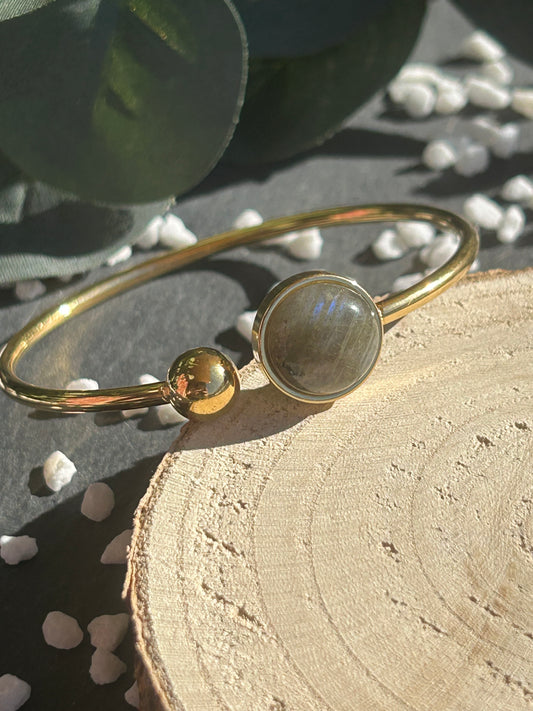 Bracelet jonc Lunae en acier inoxydable doré, orné d’un cabochon rond de 12 mm en labradorite naturelle et d’une bille fixe.