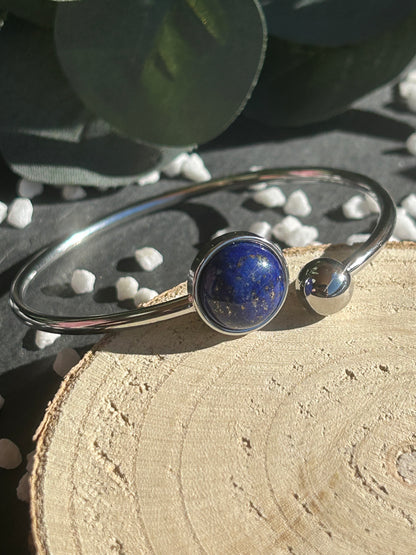 Bracelet jonc Lunae en acier inoxydable argenté, orné d’un cabochon rond de 12 mm en lapis-lazuli bleu profond et d’une bille fixe.