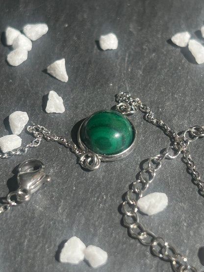 Bracelet Séléna en acier inoxydable argenté, orné d’un cabochon rond de 10 mm en malachite verte aux motifs naturels.