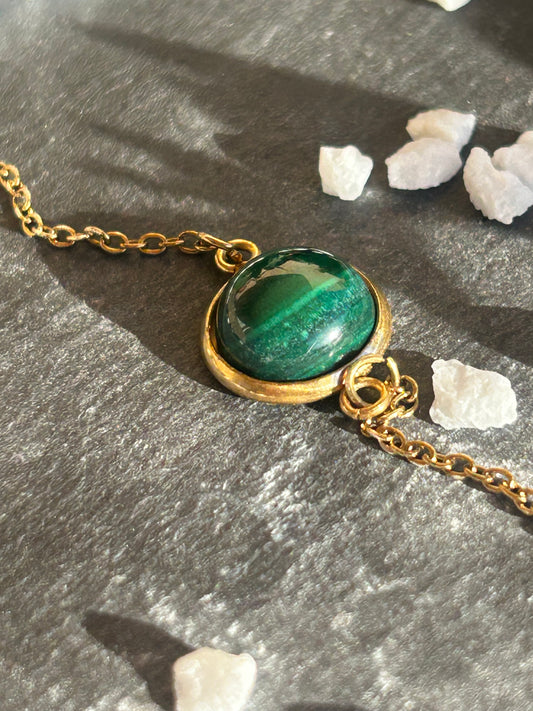 Bracelet Séléna en acier inoxydable doré, orné d’un cabochon rond de 10 mm en malachite verte aux motifs naturels.