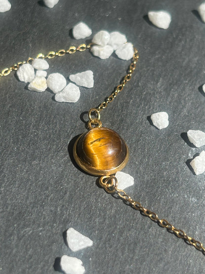 Bracelet Séléna en acier inoxydable doré, orné d’un cabochon rond de 10 mm en œil de tigre brun doré.