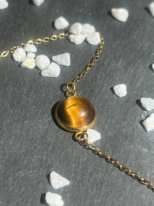 Bracelet Séléna en acier inoxydable doré, orné d’un cabochon rond de 10 mm en œil de tigre brun doré.