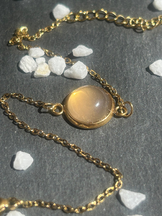 Bracelet Séléna en acier inoxydable doré, orné d’un cabochon rond de 10 mm en quartz rose naturel.