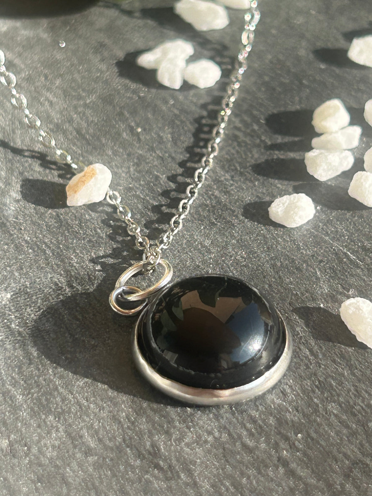 Collier Séléna en acier inoxydable argenté, avec pendentif rond de 14 mm en agate noire naturelle.