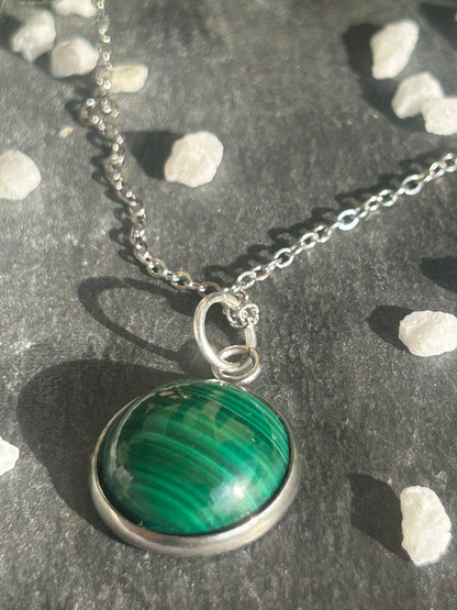 Collier Séléna en acier inoxydable argenté, avec pendentif rond de 14 mm en malachite verte aux motifs naturels.
