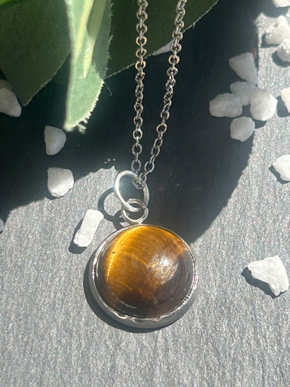 Collier Séléna en acier inoxydable argenté, avec pendentif rond de 14 mm en œil de tigre brun doré.