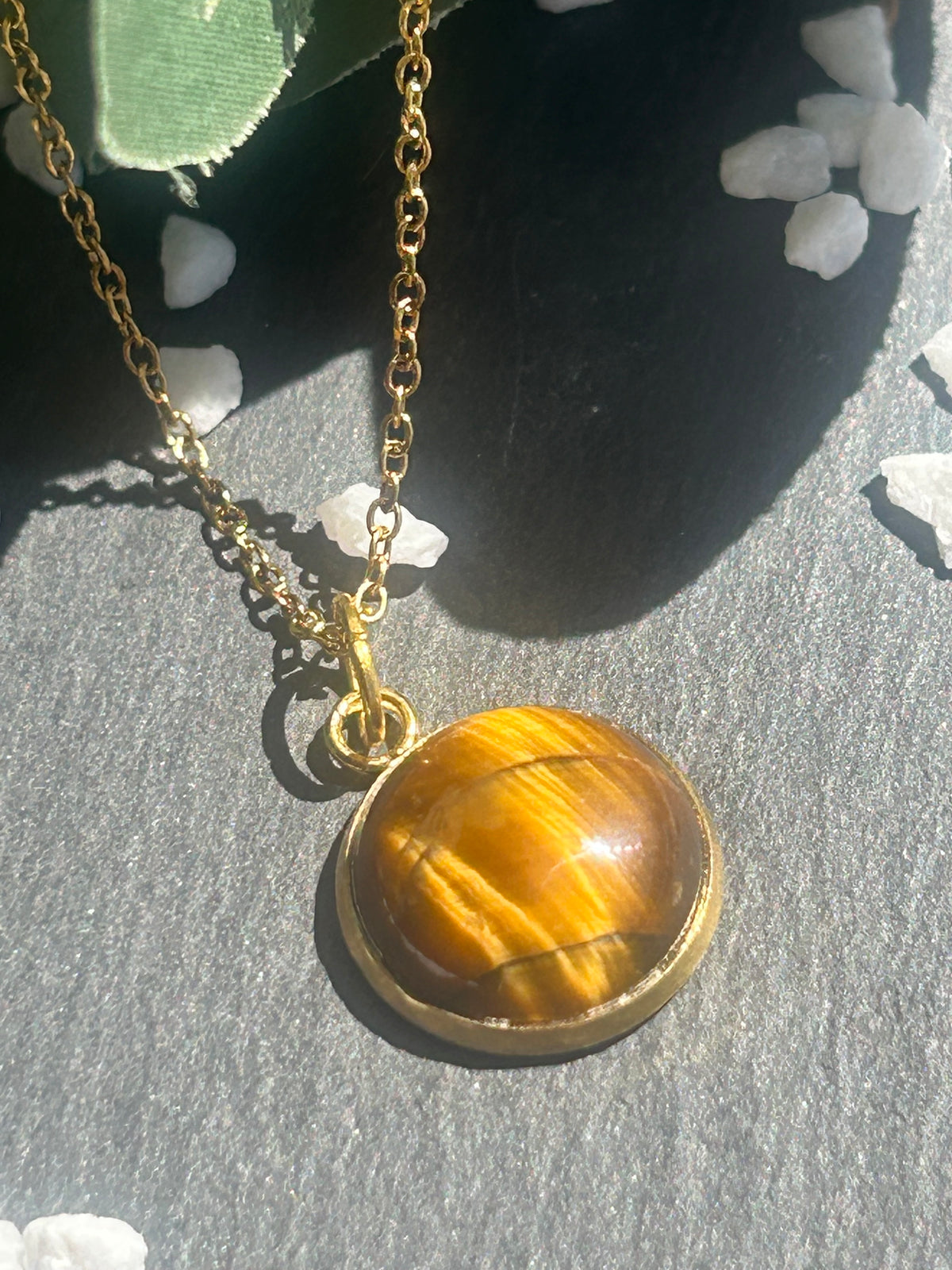 Collier Séléna en acier inoxydable doré, avec pendentif rond de 14 mm en œil de tigre brun doré.